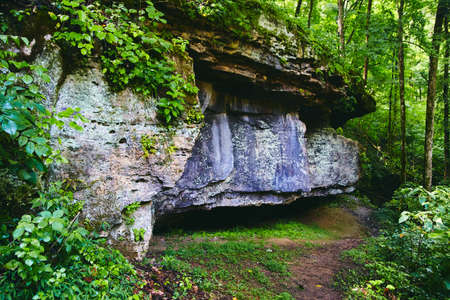 Large rock formations in park trail with green lush forestの写真素材