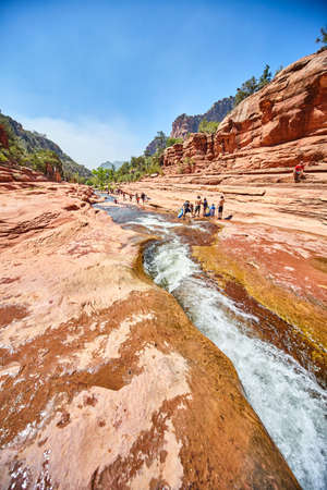 Rapids river cutting through canyon in desert with touristsの写真素材