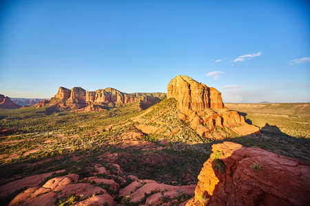 Landscape of Bell Rock peaks with scrubs at their base rising into a blue skyの写真素材