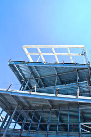 Worms eye view of stainless steel bleachers against a blue sky