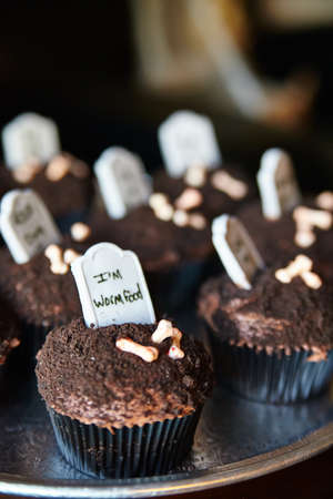 Chocolate cupcakes with candy gravestones and bones Halloween treatの写真素材