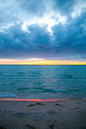 Sunset on the water with a neon orange reflection on the waters edgeの写真素材