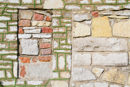 Stone background with a red square amidst green-lined stonesの写真素材