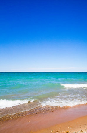 Portrait of a perfect lake horizon as the waves lap the sandy shorelineの写真素材