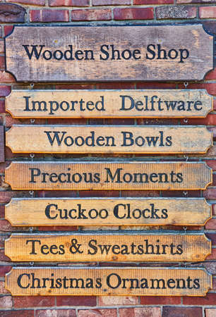 Old wall of signs in rustic dutch village on red brick backgroundの写真素材
