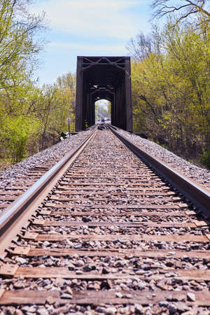 Railroad tracks leading to large metal bridgeの写真素材