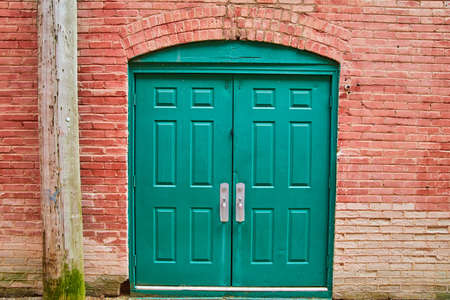 Alley double green door with red brickの写真素材