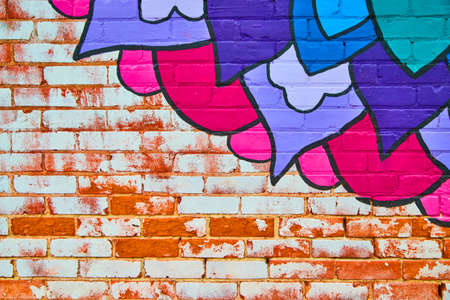 Exposed white and red brick with colorful blue and purple flower paintingの写真素材