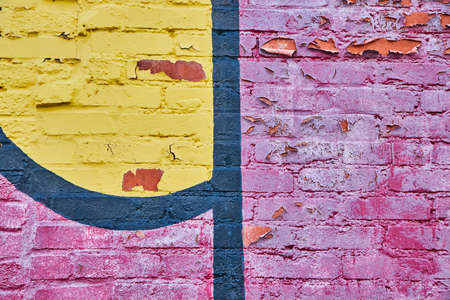 Close up of red, black, and yellow graffiti on brickの写真素材
