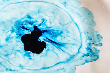 Blue dye falling into a blue water droplet that looks blackの写真素材
