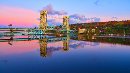 Aerial of lift bridge in Houghton over the lake with fall trees and a city during sunriseの写真素材