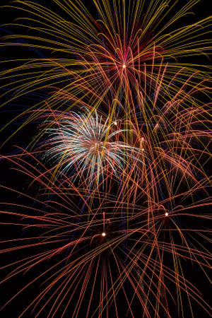 Sparks fly with fireworks in the sky at night