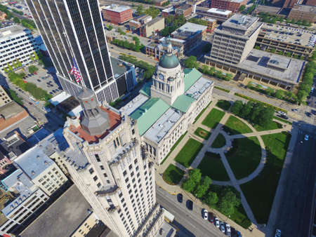 Aerial shot of downtown Fort Wayne Indiana by the courthouse showing a manicured green courtyard and several skyscrapers and high rise buildingsの写真素材