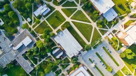 Birds eye view of a college campus with roads cutting through green lawns between buildings in a geometric designの写真素材