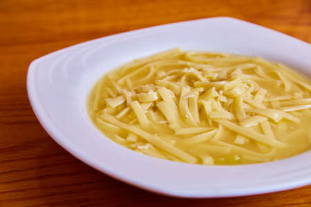 Clean white bowl with warm and hearty chicken noddle soupの写真素材