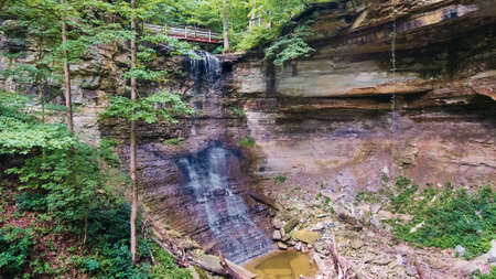 Waterfall into deep gorge with walking bridge aboveの写真素材