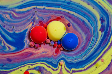 Red, yellow, and blue spheres on colorful rainbow surface