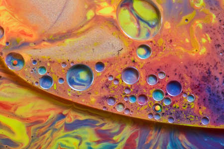 Sparkling liquid surface of rainbow colors and cool colored spheres