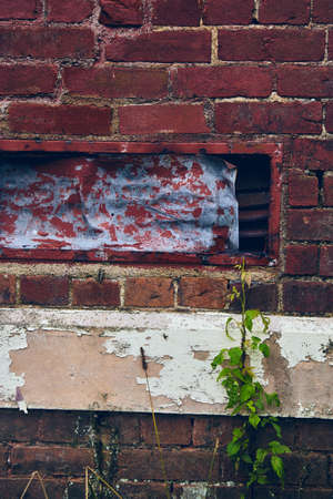 Abandoned building close-up of red brick wall with holes and peeling paint