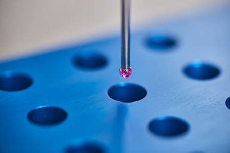 Blue test block with CMM Programming probe featuring purple tipの写真素材