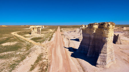 Aerial of desert road with large white rock pillarsの写真素材