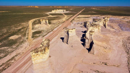 Aerial view of large pillars of white rock sticking out of flat country desertの写真素材