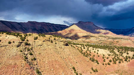 Storm clouds casting shadow over desert mountainsの写真素材