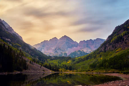 Cloudy sunrise view of majestic Maroon Bells mountain rangeの写真素材