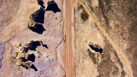 Aerial looking down at desert road with pillars of rockの写真素材