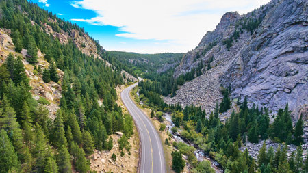 Beautiful road highway through canyon next to country mountains and forest of pine treesの写真素材