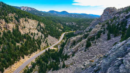 Traveling road tourism through the mountains next to stone peaks and pine treesの写真素材