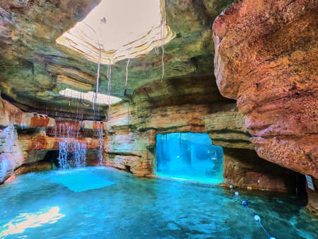 Underground manmade waterfall next to aquariumの写真素材
