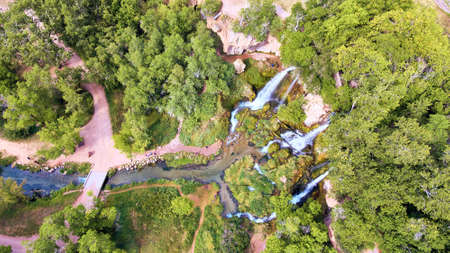 Aerial down view of park with three waterfalls into one riverの写真素材