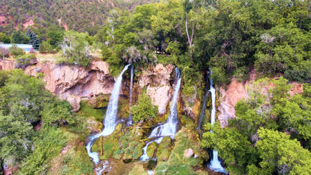 Triple waterfall over mossy rocks in forestの写真素材
