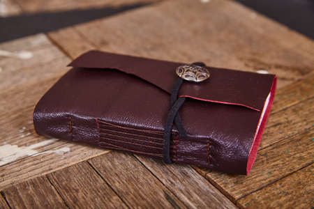 Purple leather journal detail closed on wood boardsの写真素材