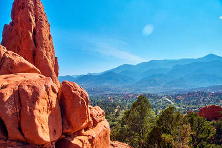 Detail of large red rocks with mountain desert landscape in background