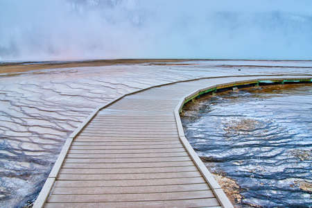 Boardwalk over small terraces with trickling waters in Yellowstoneの写真素材