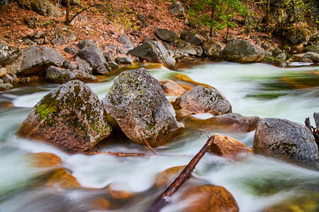 Close-up of boulders in river with water cascading over