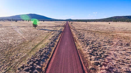 Large red sandy desert road leading through plainsの写真素材