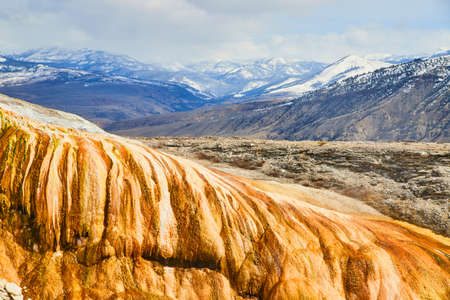 Snowy mountains with warm and colorful mounds at Yellowstoneの写真素材