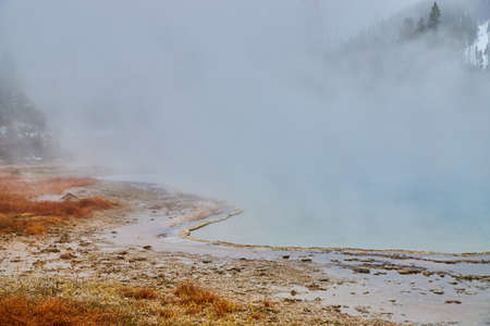 Yellowstone pools in spring covered in sulfuric steam