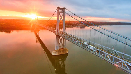 Magical golden sunrise over Hudson river bridge in New York from drone over waterの写真素材