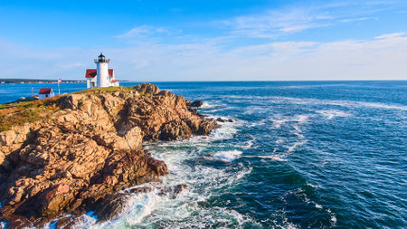Stunning lighthouse of Maine aerial on rocky island with morning light and waves crashing on coastsの写真素材