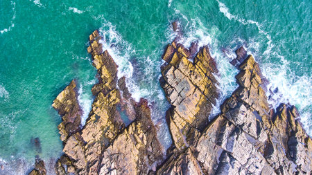 Aerial looking down on patch of rocky coasts in Maine with crashing wavesの写真素材