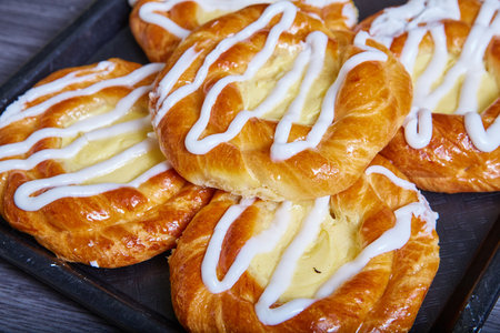 Tray cream cheese filled Danish pastry baked good with white frosting drizzled on topの写真素材