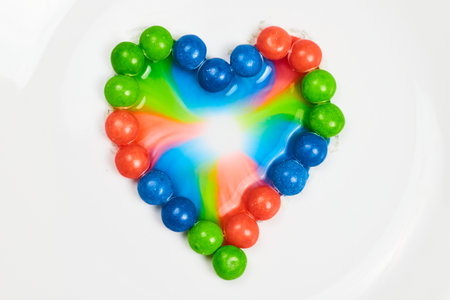 Tie dye effect from blue and green and pink skittle heart backgroundの写真素材