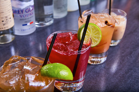 Tequila margarita flight cranberry vodka alcohol drinks colorful collection black straws on iceの写真素材