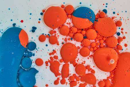 Orange and blue spheres and bubbles dancing on white background assetの写真素材