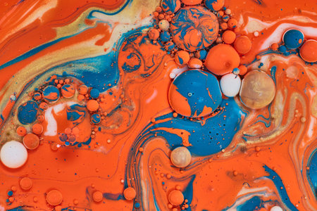 Abstract painting with multiple colors of acrylic paint swirling with bubbles of gold blue white and...