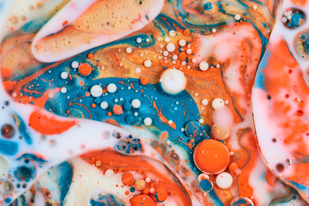Abstract sea of milky white with acrylic pouring of oil and blue orange and gold paints creating background assetの写真素材